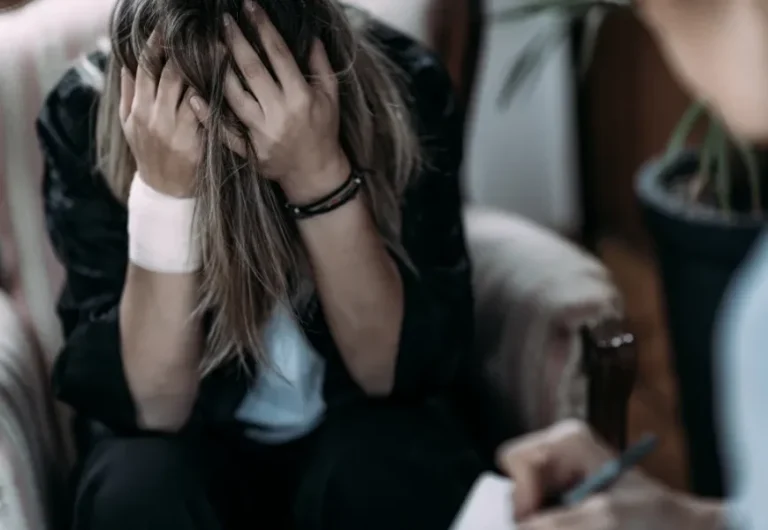 Person holding their head in distress, representing living with PTSD