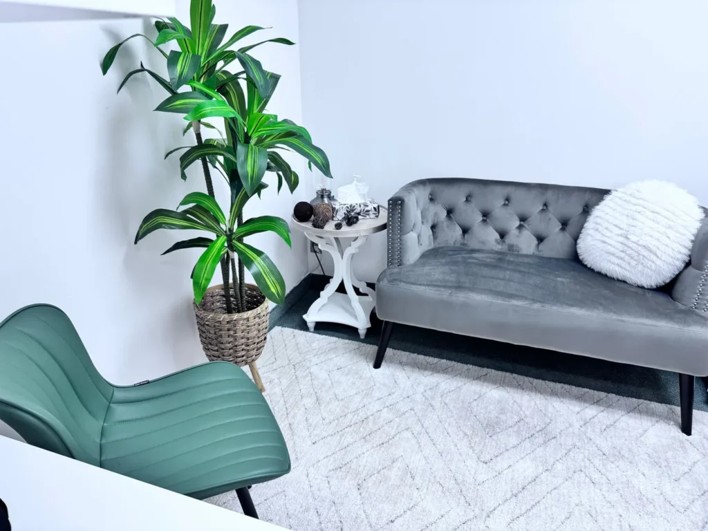 Calming therapy room with a sofa and armchair at Batool Psychotherapy in Vaughan